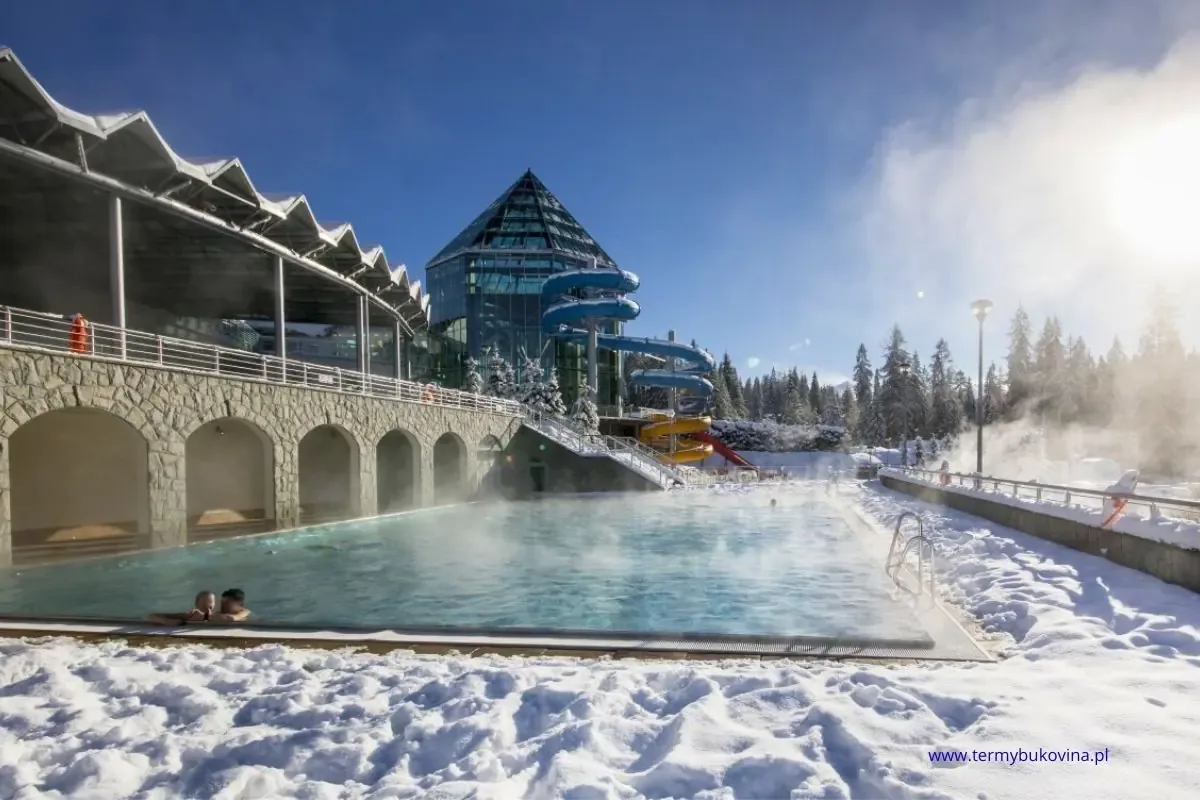 Zewnętrzny basen Termy Bukovina zimą z widokiem na Tatry – popularna atrakcja dla turystów szukających relaksu poza stokiem.