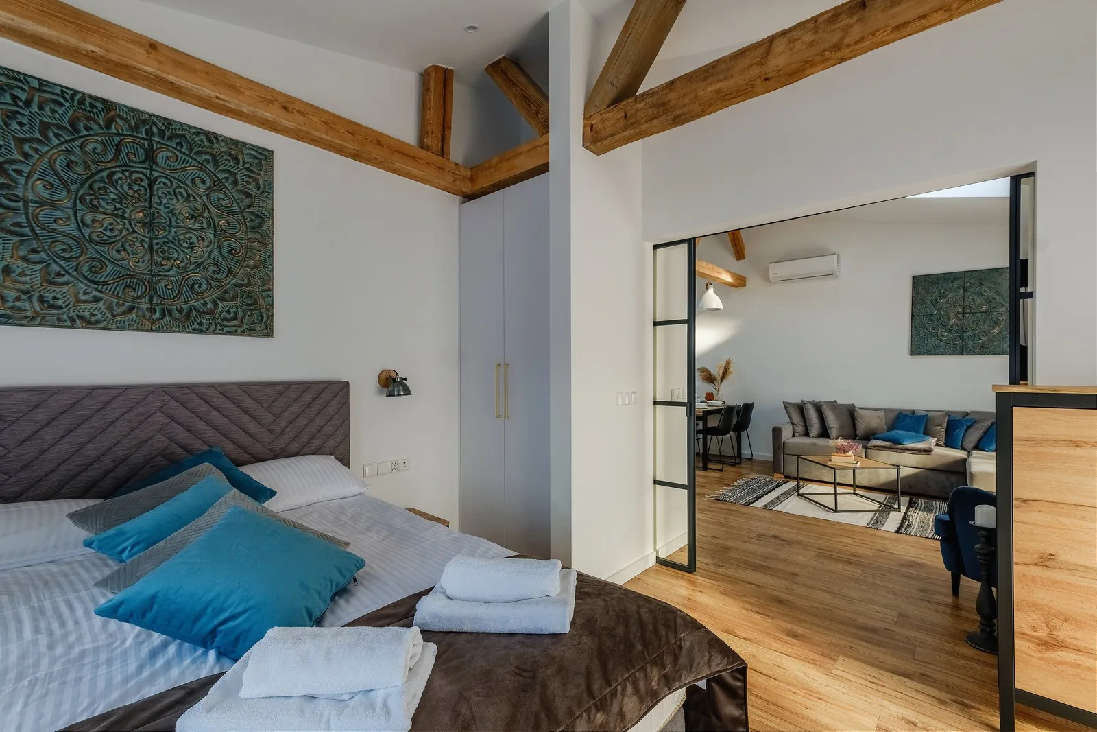 Sypialnia apartamentu Dolina Kasprowa, Rezydencja Ornak 5 Zakopane – duże łóżko małżeńskie i widok na salon