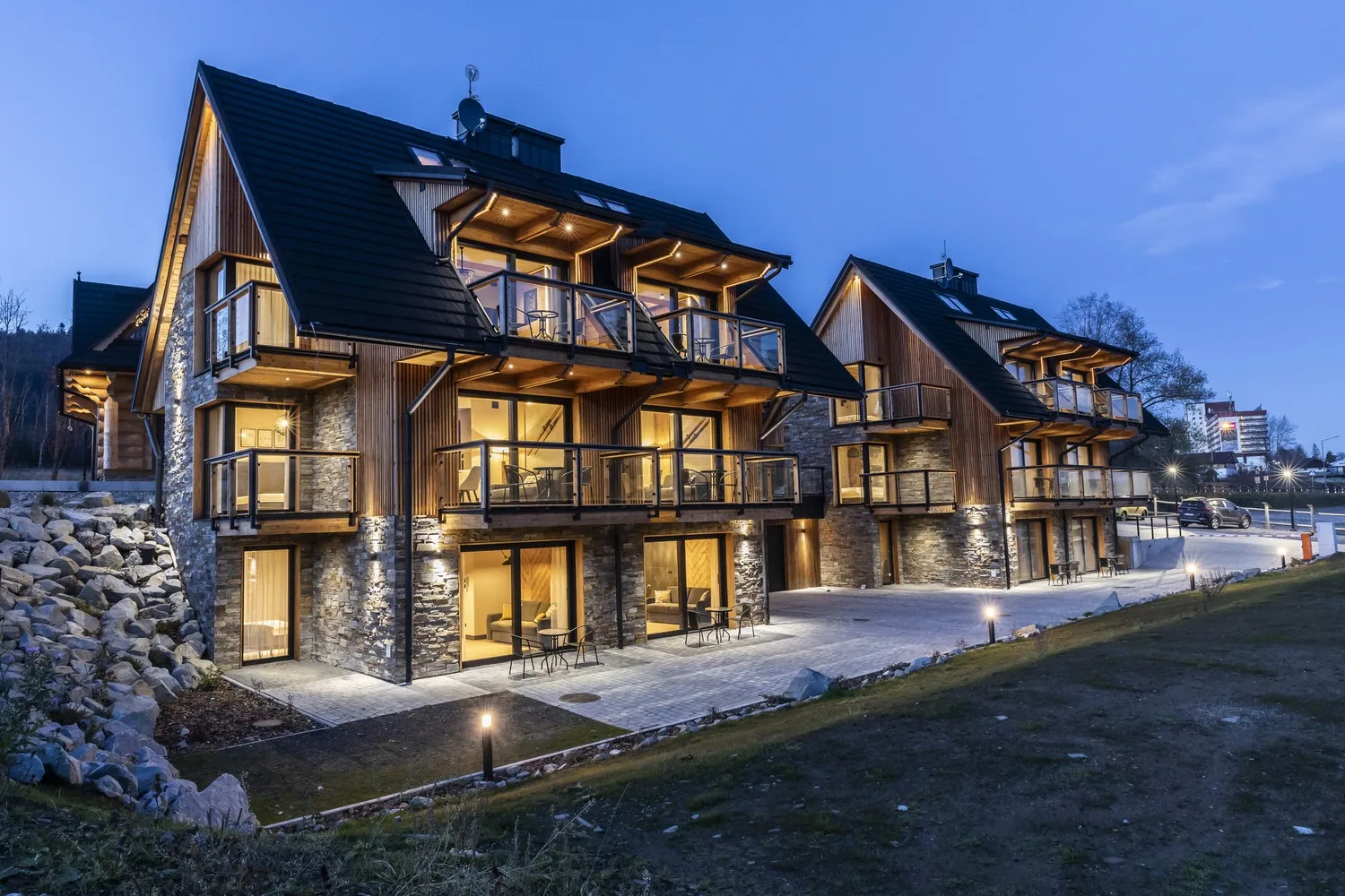Zakopane – nocny widok na Szymaszkowa 7 z iluminacją budynku, oświetlonymi apartamentami i tarasem