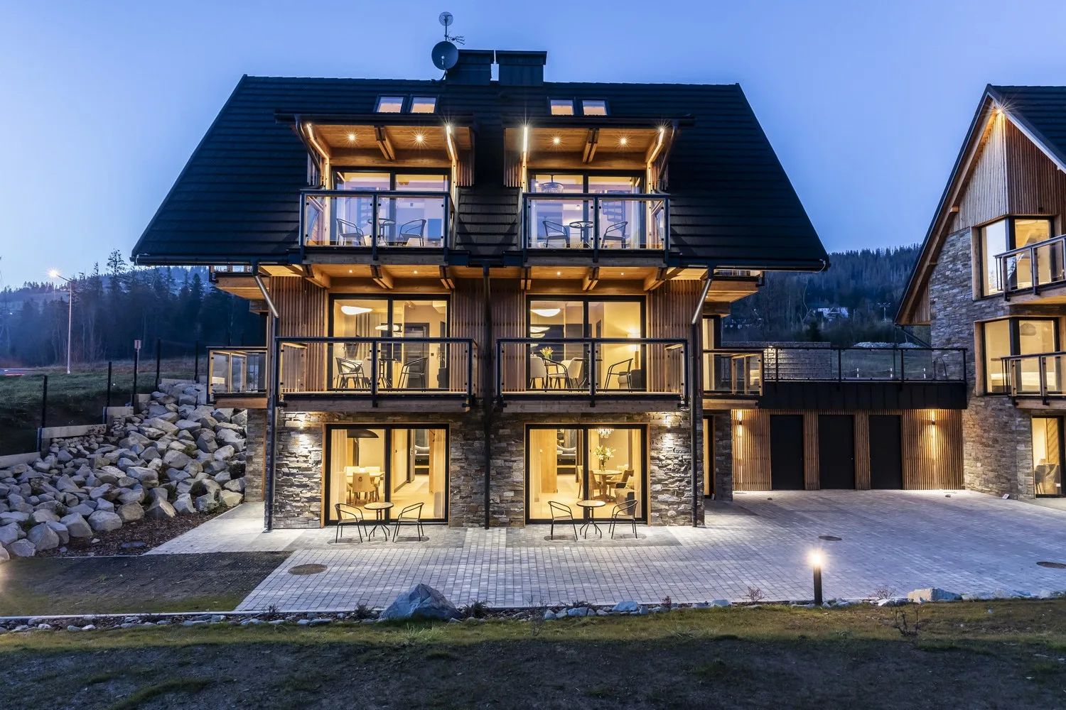 Wieczorne ujęcie budynku Szymaszkowa 7 z podświetlonymi apartamentami i tarasami