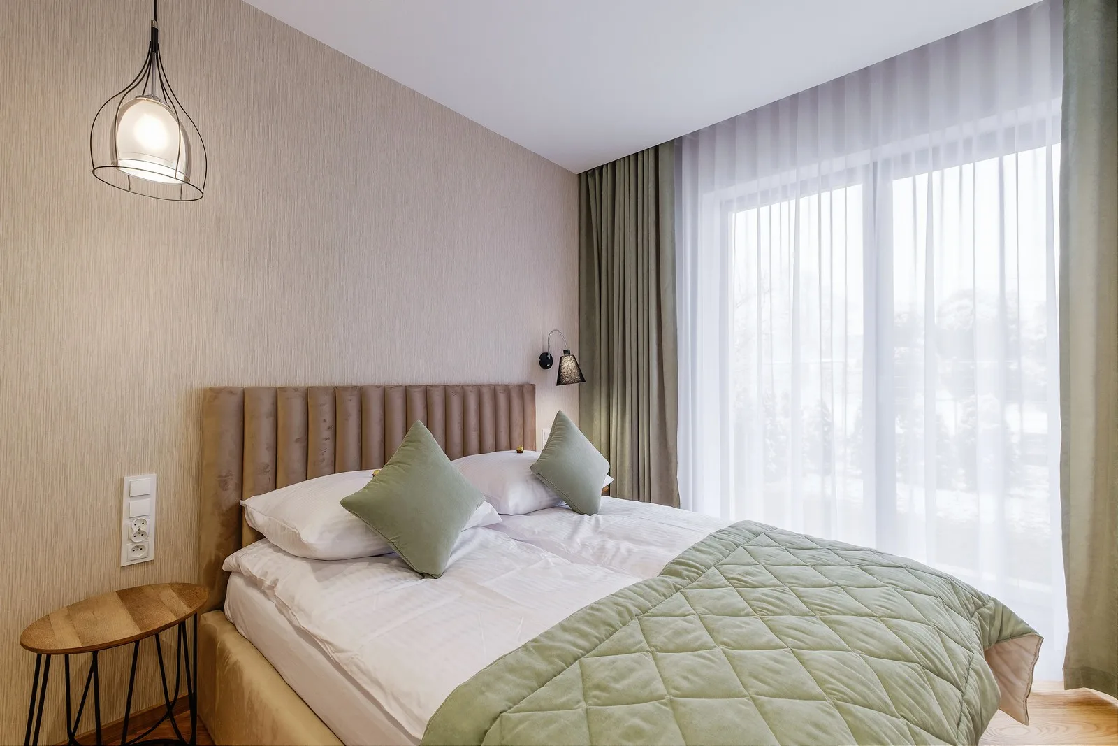 Sypialnia apartamentu Kornwalia, Orkana 14A Nowy Targ – duże łóżko małżeńskie i drzwi tarasowe prowadzące do ogródka